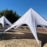 Dwa namioty Gwiazda na plaży nad Wisłą w Warszawie z panoramą Starówki