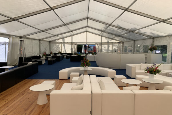 Duża biała hala namiotowa z białymi meblami loungeowymi i sceną na event firmowy – wynajem