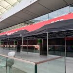 Długi czerwony namiot cateringowy przy przeszklonej fasadzie podczas eventu LiveNation, Warszawa – wynajem