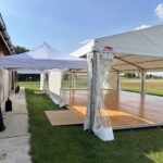 Hala namiotowa z drewnianą podłogą i namiot ekspresowy jako przejście przy stodole – wynajem na wesele