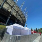Białe namioty ekspresowe przy fasadzie PGE Narodowego w Warszawie, ogrodzone barierkami – wynajem na event