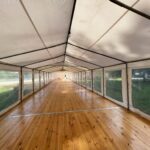 Podłoga drewniana modułowa pod namiot eventowy w plenerze – stabilne podbudowanie na trawie, wynajem